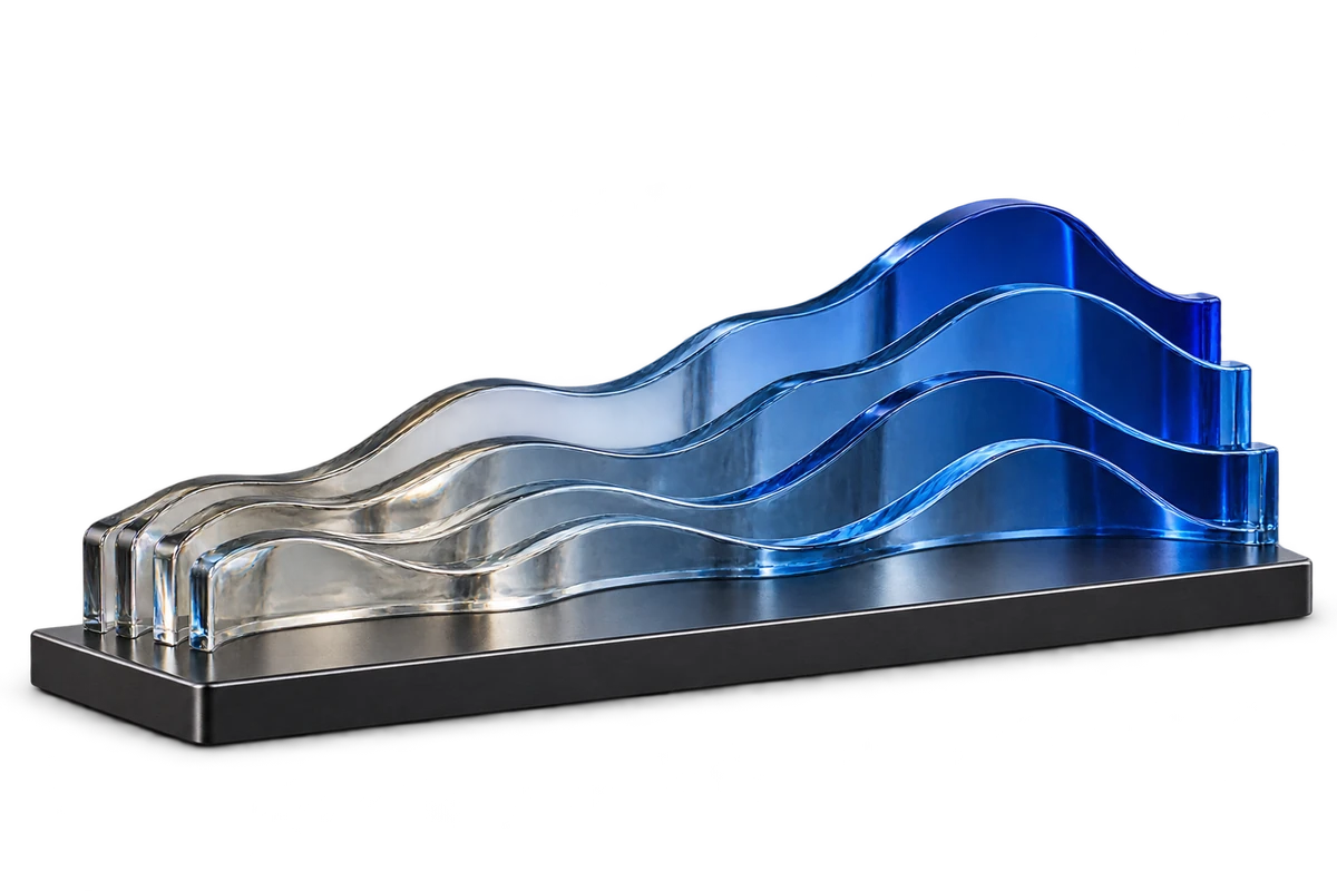 Abstract glass sculpture with curved ribbons transitioning from clear glass to cobalt blue.